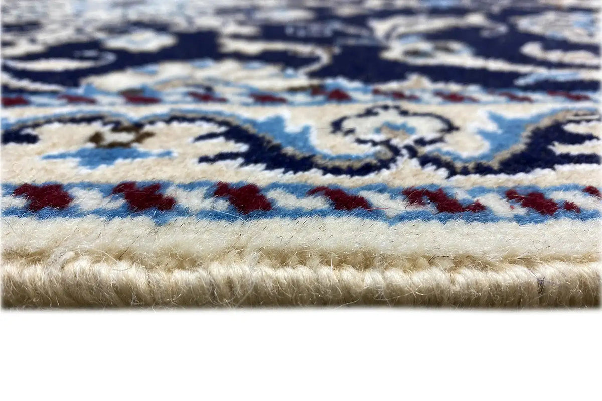 Rug edge with fringe: dark blue pattern and light border in detail