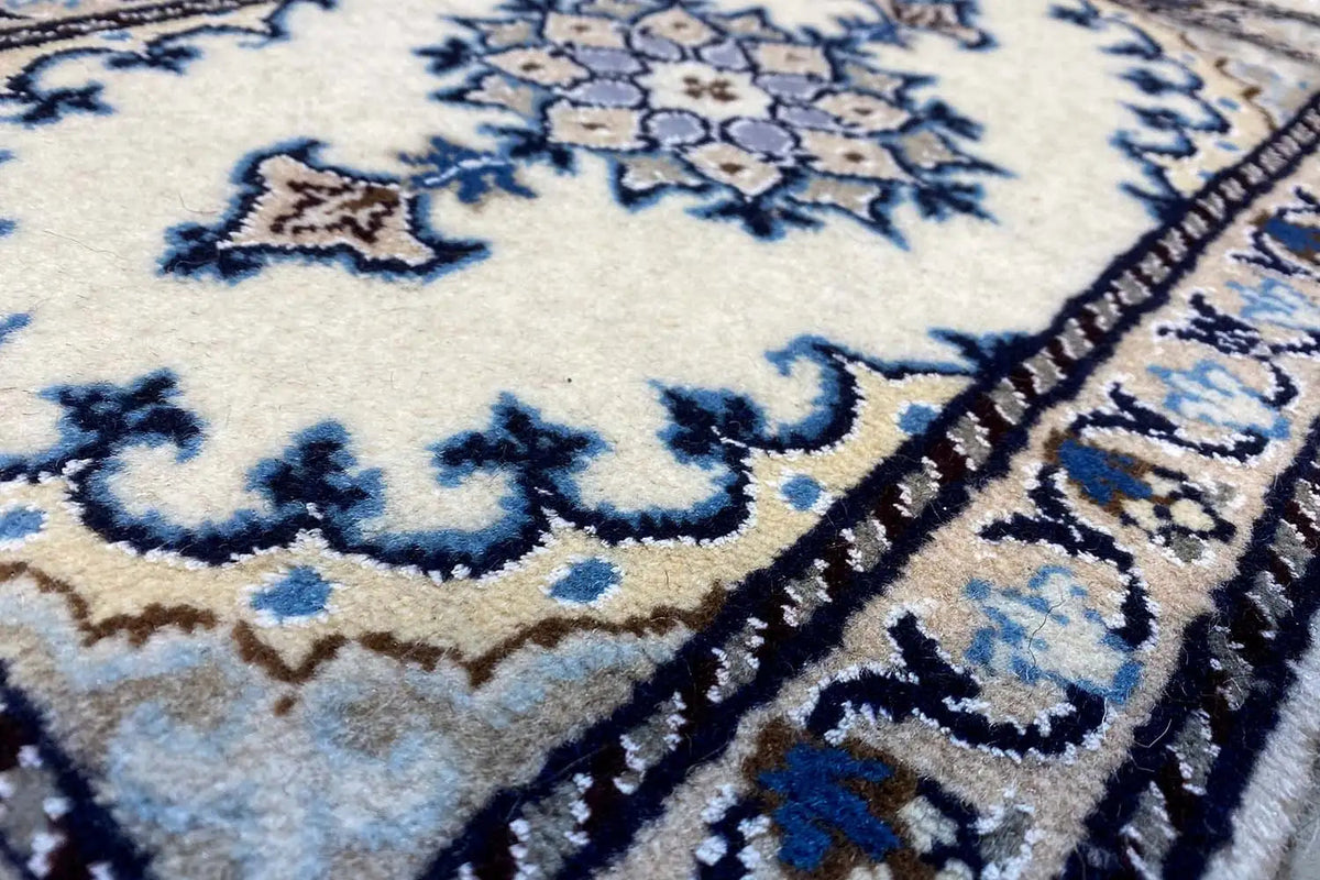 Nain rug detail: blue-and-white ornamental pattern, dense pile, decorative border