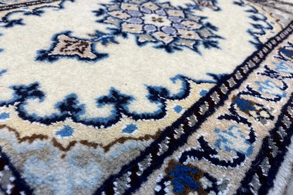Nain rug detail: blue-and-white ornamental pattern, dense pile, decorative border