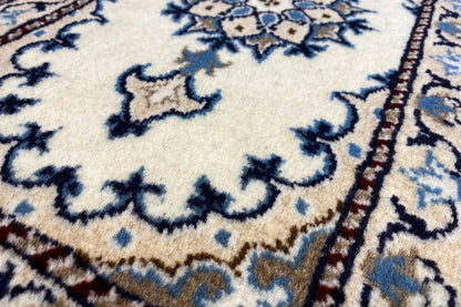 Close-up: light carpet field with a blue floral ornament and border