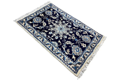 Rug 88x59 cm in blue, diagonal view with an ornamental central medallion and fringes
