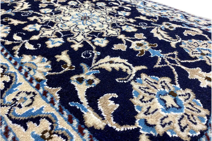 Close-up: blue carpet with white ornaments and a fine border in the pile