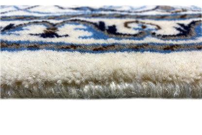 Carpet fringe at the edge, blue-and-white border and floral pattern, textured wool