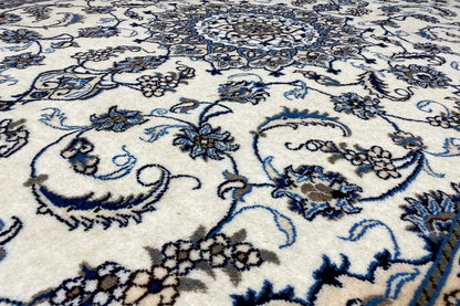 Close-up of carpet fabric: blue floral pattern on a light background, fine texture