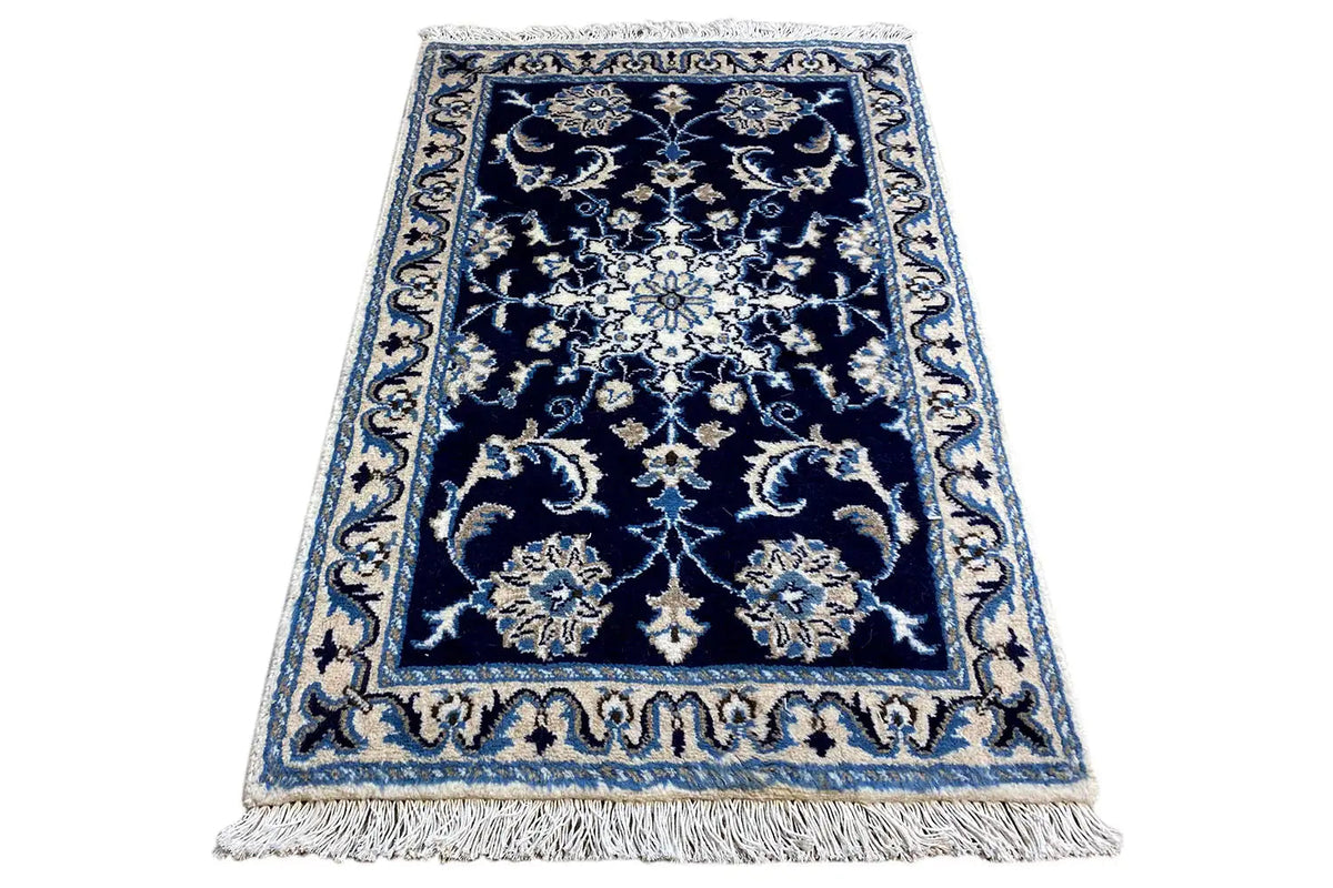 Blue rug with fringe and dark blue medallion pattern, accented in light blue