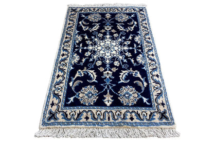 Blue rug with fringe and dark blue medallion pattern, accented in light blue