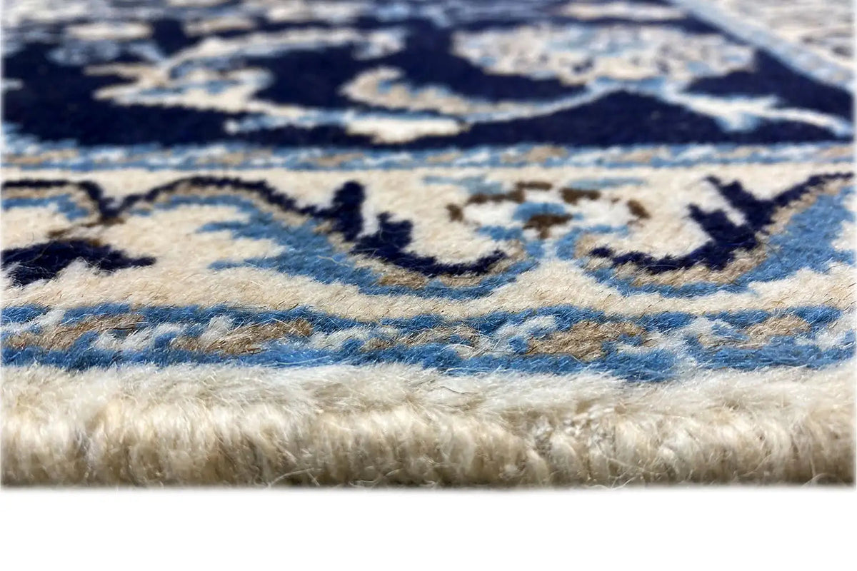 Detail of the carpet edge: fringes and a blue-beige ornamental pattern, close-up