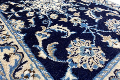 Close-up of the rug with floral ornaments, a dark blue background, and light accents