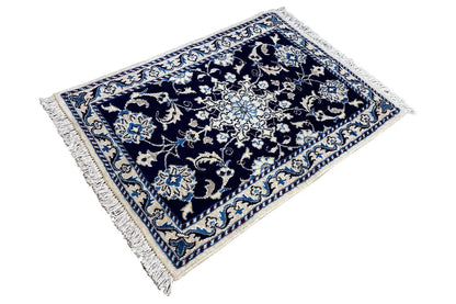 Nain rug 90x61 cm, photographed at an angle, with fringes and light blue details in the pattern