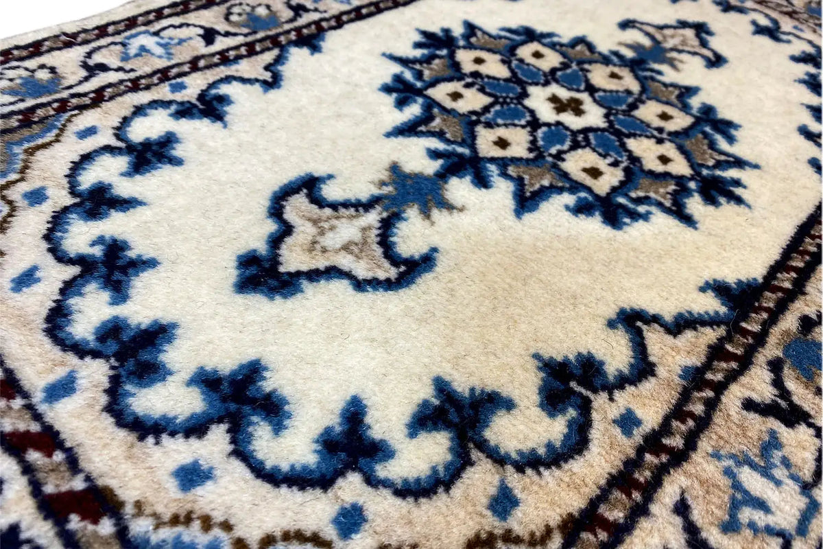 Nain rug: detail of the blue ornamental medallion on a white background