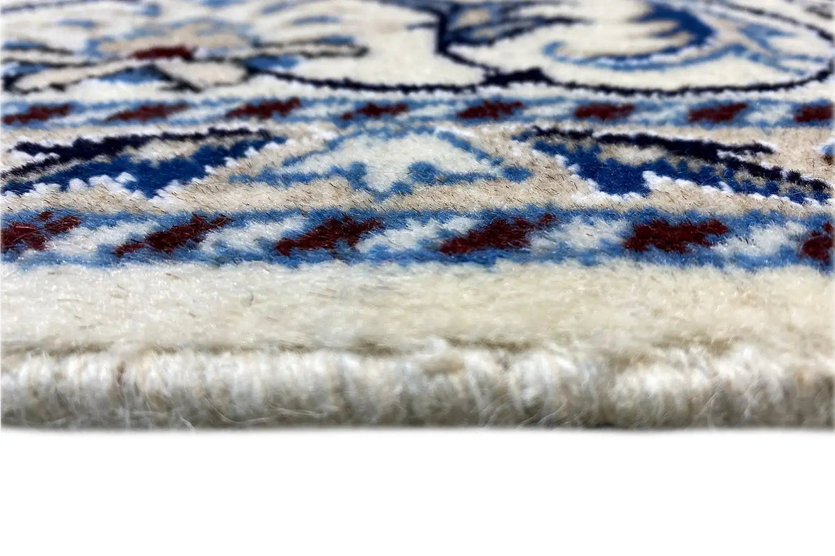 Carpet fringe at the edge, blue-and-white pile with fine pattern details