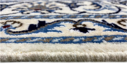 Carpet edge in detail: blue-and-white ornamental border on a light pile