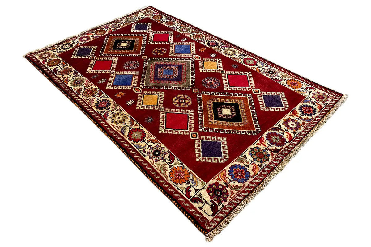 Oriental rug, red background with diamond and square patterns in blue and beige, fringes