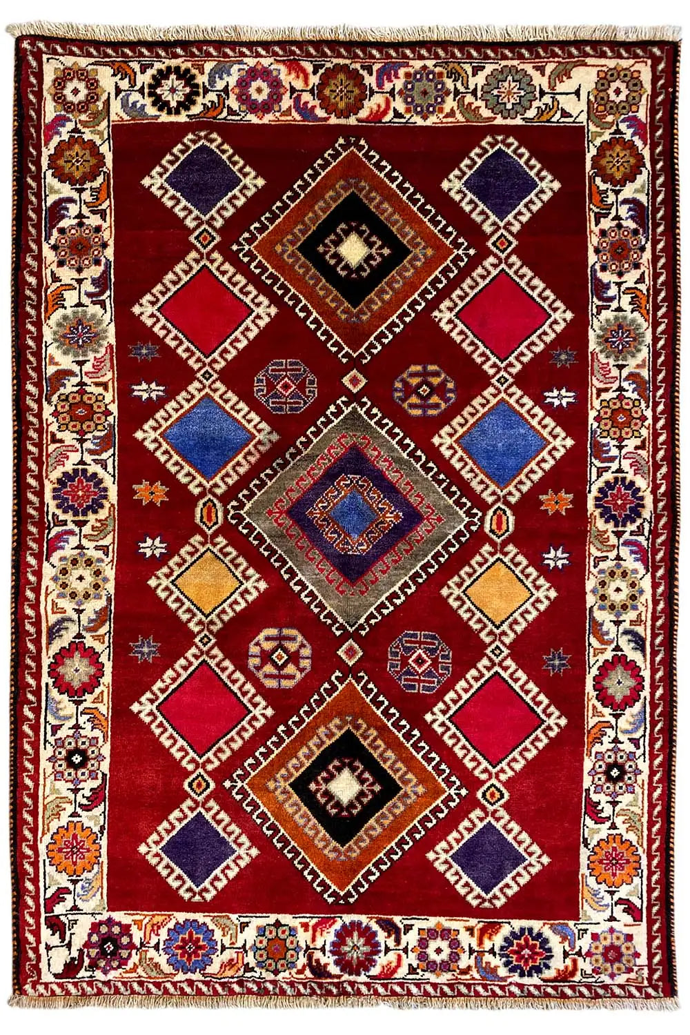 Oriental rug with a red background, geometric pattern in blue, beige, and black, border