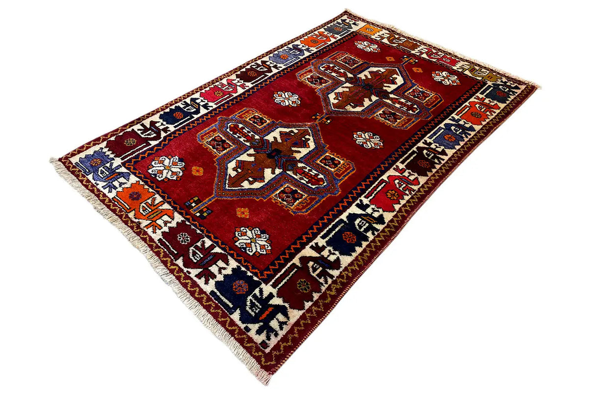 Red rug with Shiraz-Qashqai ornaments, borders and fringes, laid flat