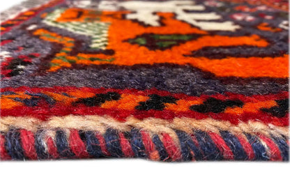 Detail: hand-knotted rug with a multicolored border and fringes along the edge