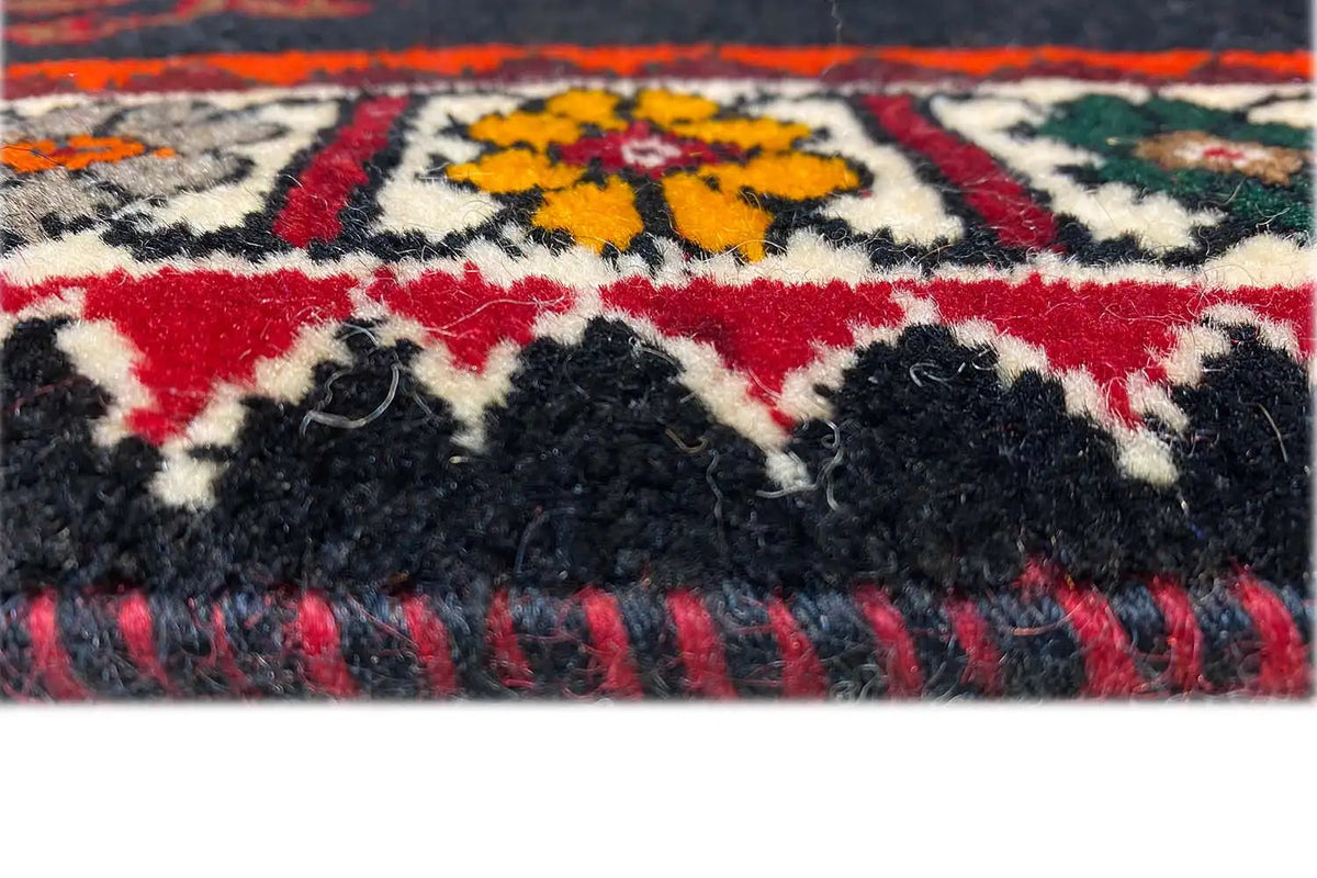 Close-up: burgundy carpet with a fluffy pile texture and color border