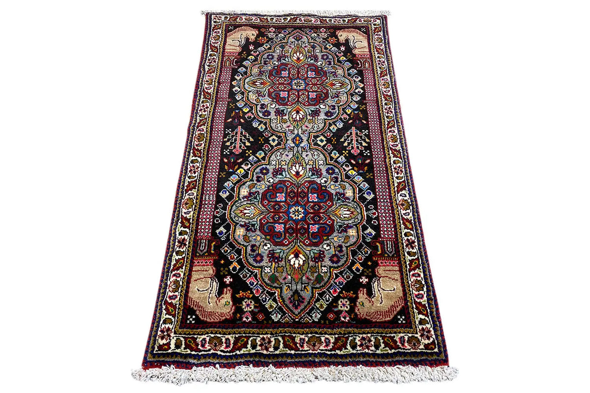 Oriental rug with medallion design and fringes, dark background, 114x59 cm.