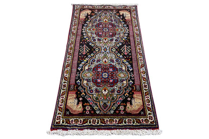 Oriental rug with medallion design and fringes, dark background, 114x59 cm.