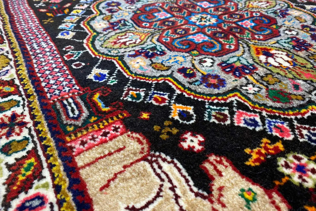 Close-up of the carpet surface with medallion patterns and multicolored pile.