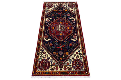 Oriental rug with a red border, dark medallion, and fringes