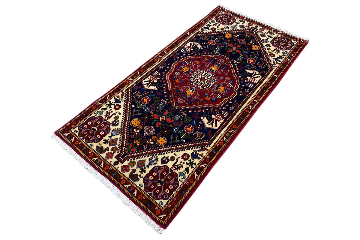 Oriental rug with a dark central medallion, cream-colored border, and fringes