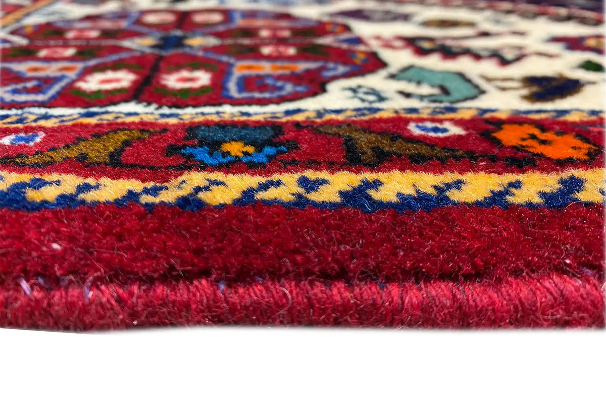 Rug pile with red pile and a colored patterned stripe, with fringes on the sides