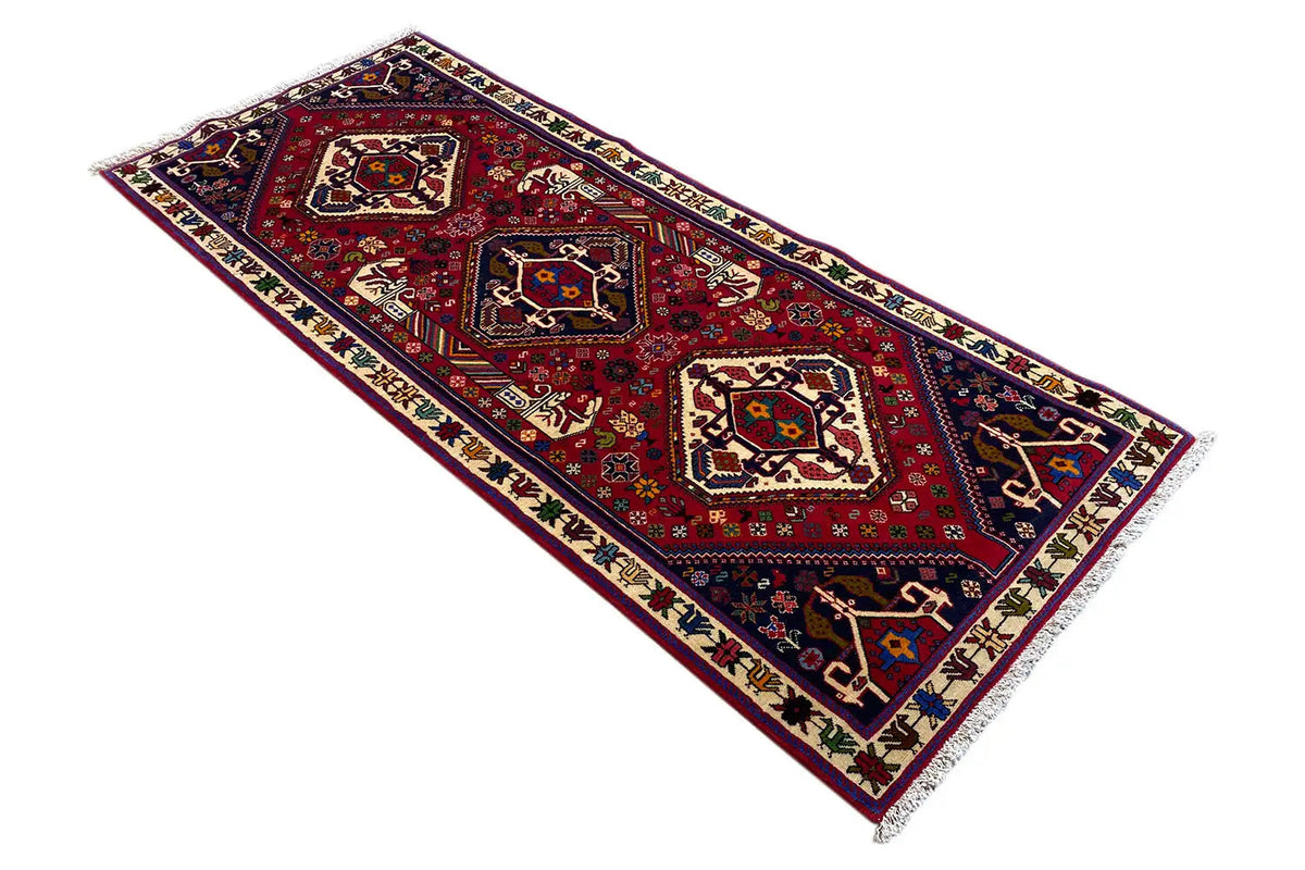 Flat-weave rug with a red geometric pattern, a blue/cream border, and fringes.