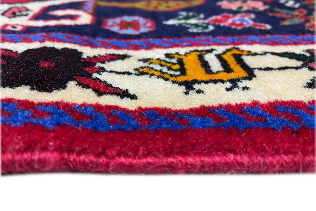 Carpet detail: soft pile, red-and-blue pattern, and multicolored border.