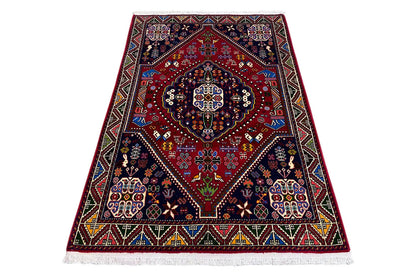 Oriental rug with a red center and dark blue ornaments, with a colorful edge border
