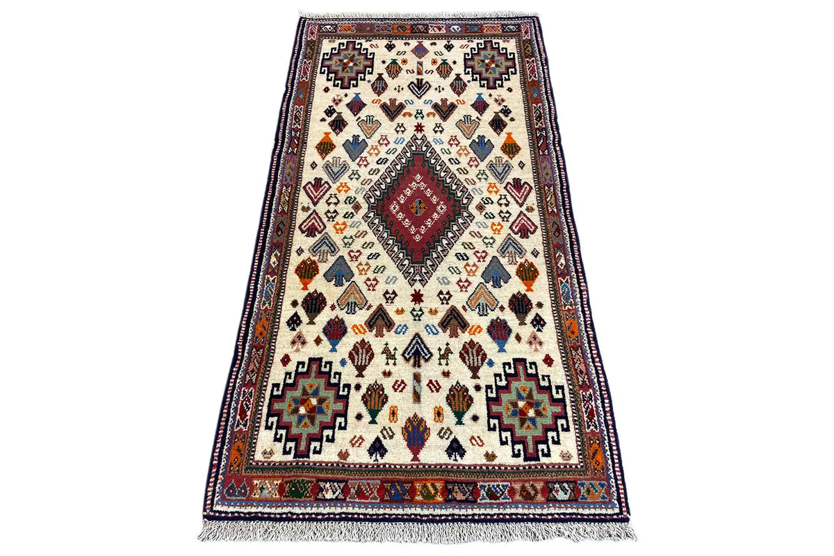 Oriental rug with geometric pattern in cream, blue, red, and yellow, 137x72 cm