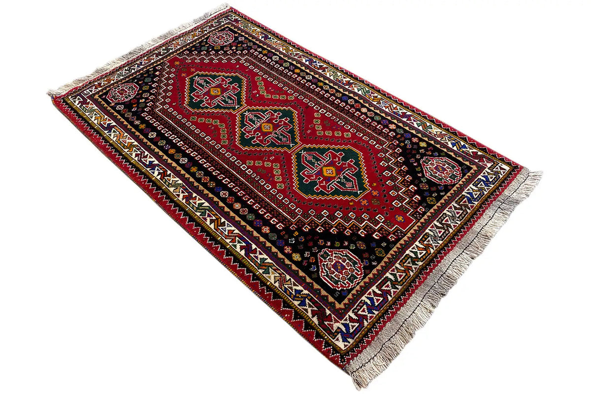 Rug at an angle: geometric medallion pattern, red, dark blue, and fringe