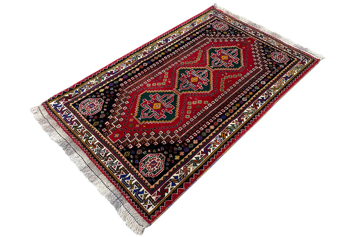 Rug with a geometric pattern in red, dark blue and green, multicolored border, fringes
