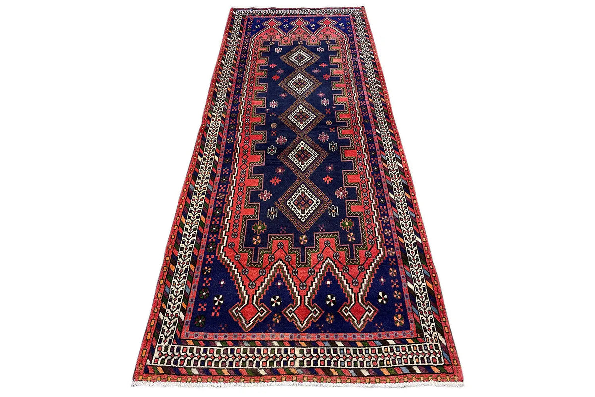 Sirjan runner viewed at an angle, blue with a red border and geometric ornamental pattern.