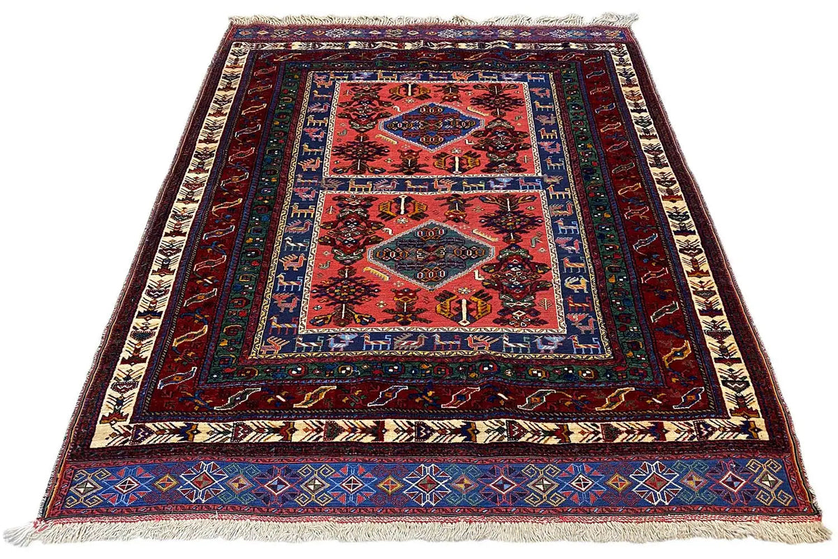 Rug with a red central area and a geometric blue border, fringes on the sides