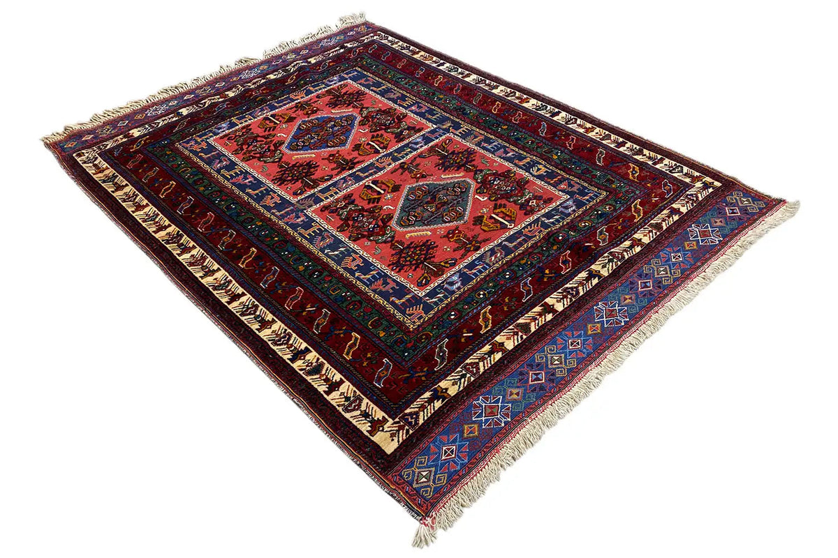Triangle-shaped rug with a red pattern, dark blue border, and fringe