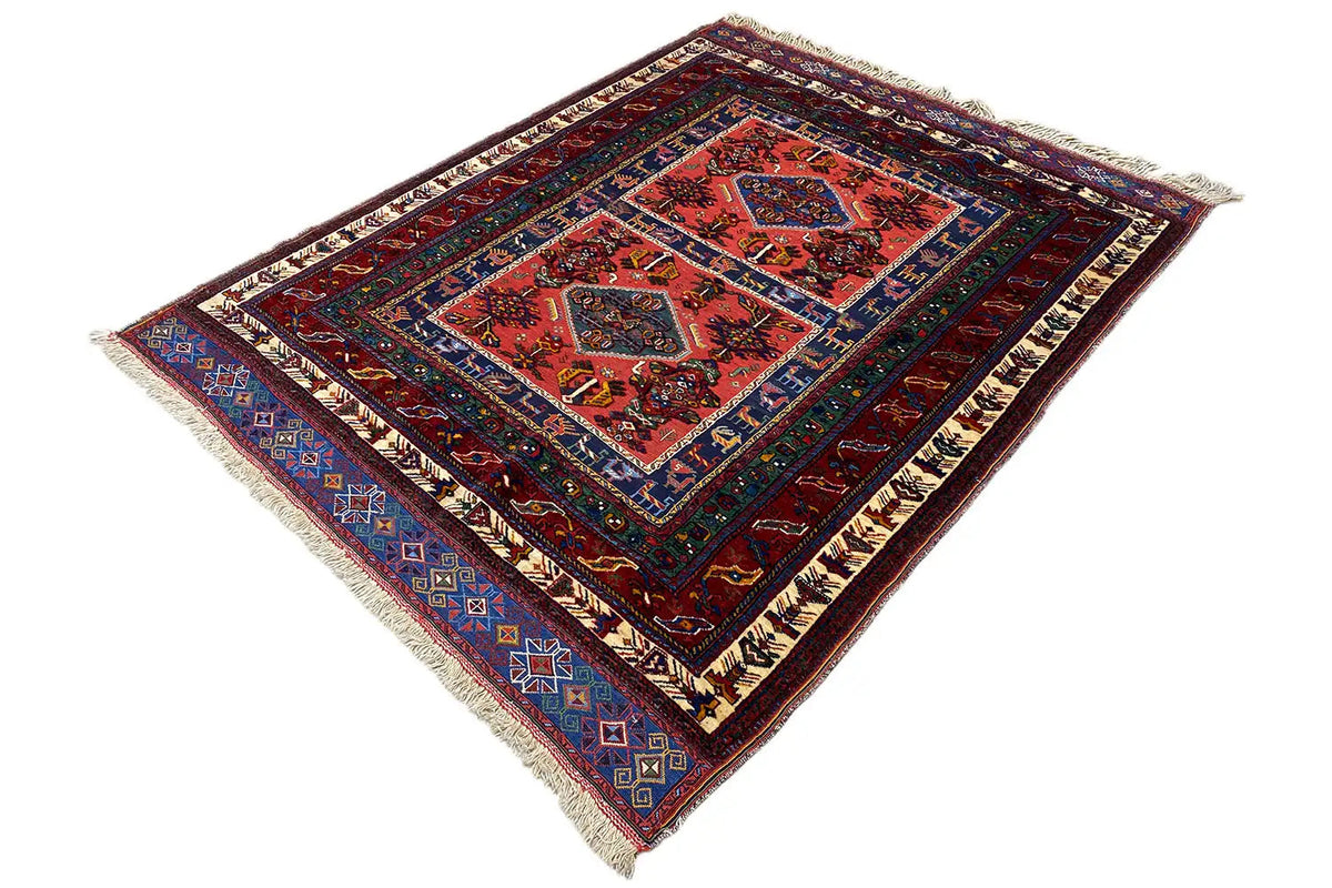 Rug with a red central medallion, dark blue border, and fringes on all sides