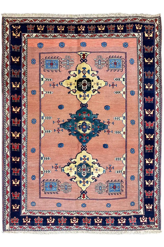 Oriental rug with a symmetrical medallion in pink, blue, yellow, and dark blue areas