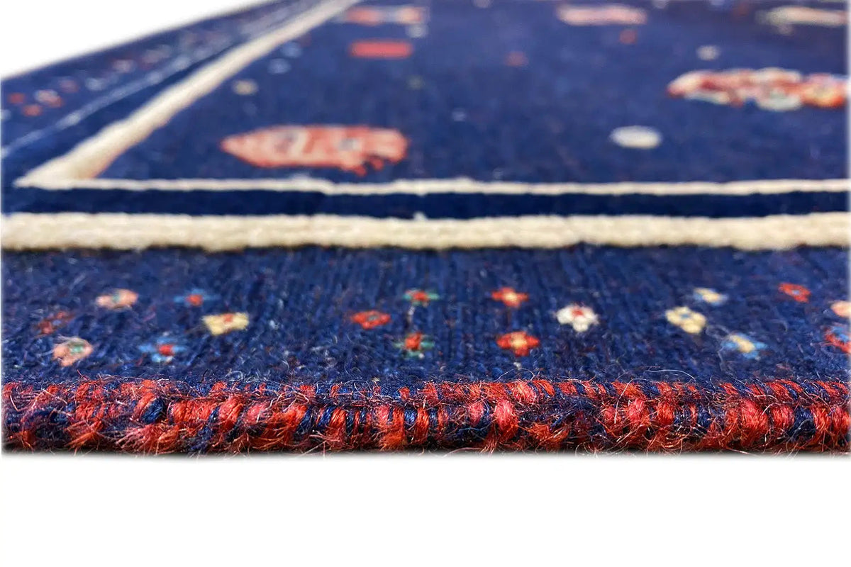 Soumak rug, detail: colorful fringes and woven edge on a dark blue background