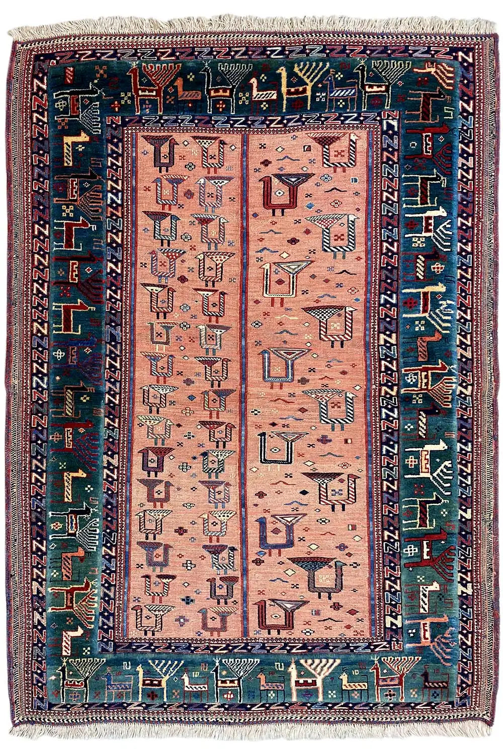 Rug with a rectangular central field, pink-beige background, blue patterned border, fringes