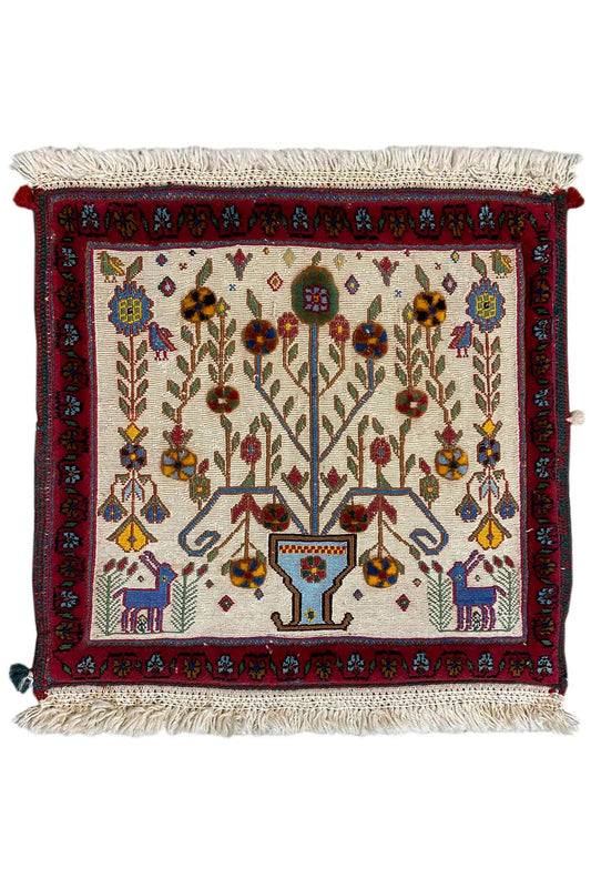 Decorative cushion cover with an all-over pattern, red trim, and tassels on the sides