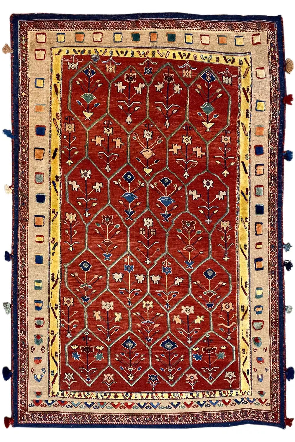 Reddish-brown oriental rug with a red medallion pattern, blue border, and tassels
