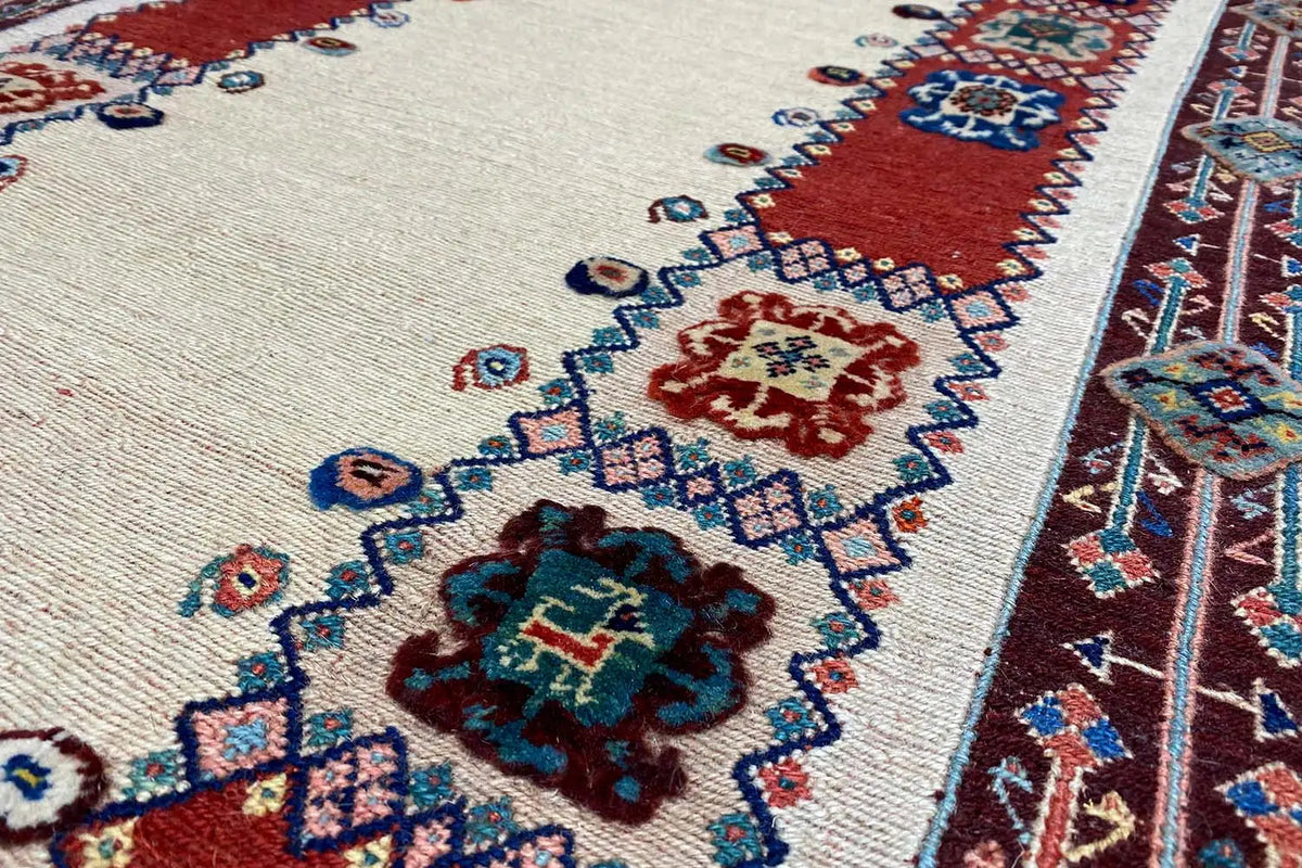 Runner detail: beige background with floral ornaments in blue, red and green