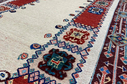 Runner detail: beige background with floral ornaments in blue, red and green