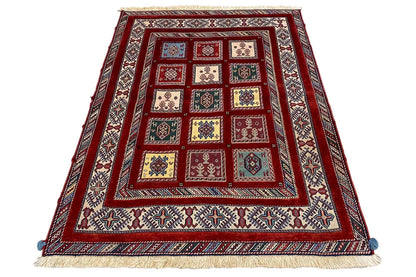 Oriental rug with a red central pattern, a surrounding border, and fringes at the corners