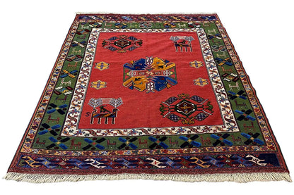 Rug with a red center and geometric motifs, colorful border, with fringes