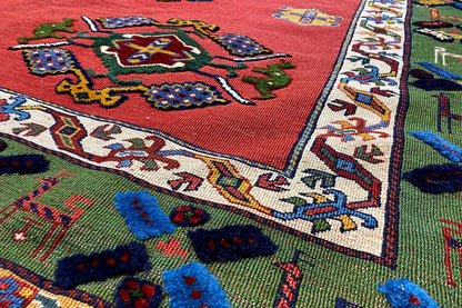 Close-up of the carpet edge: red background with multicolored ornaments, woven border