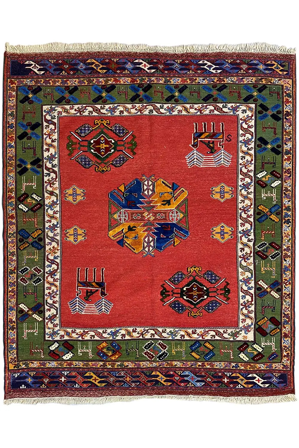 Rug with a red background, multicolored ornaments and a woven border, with fringes