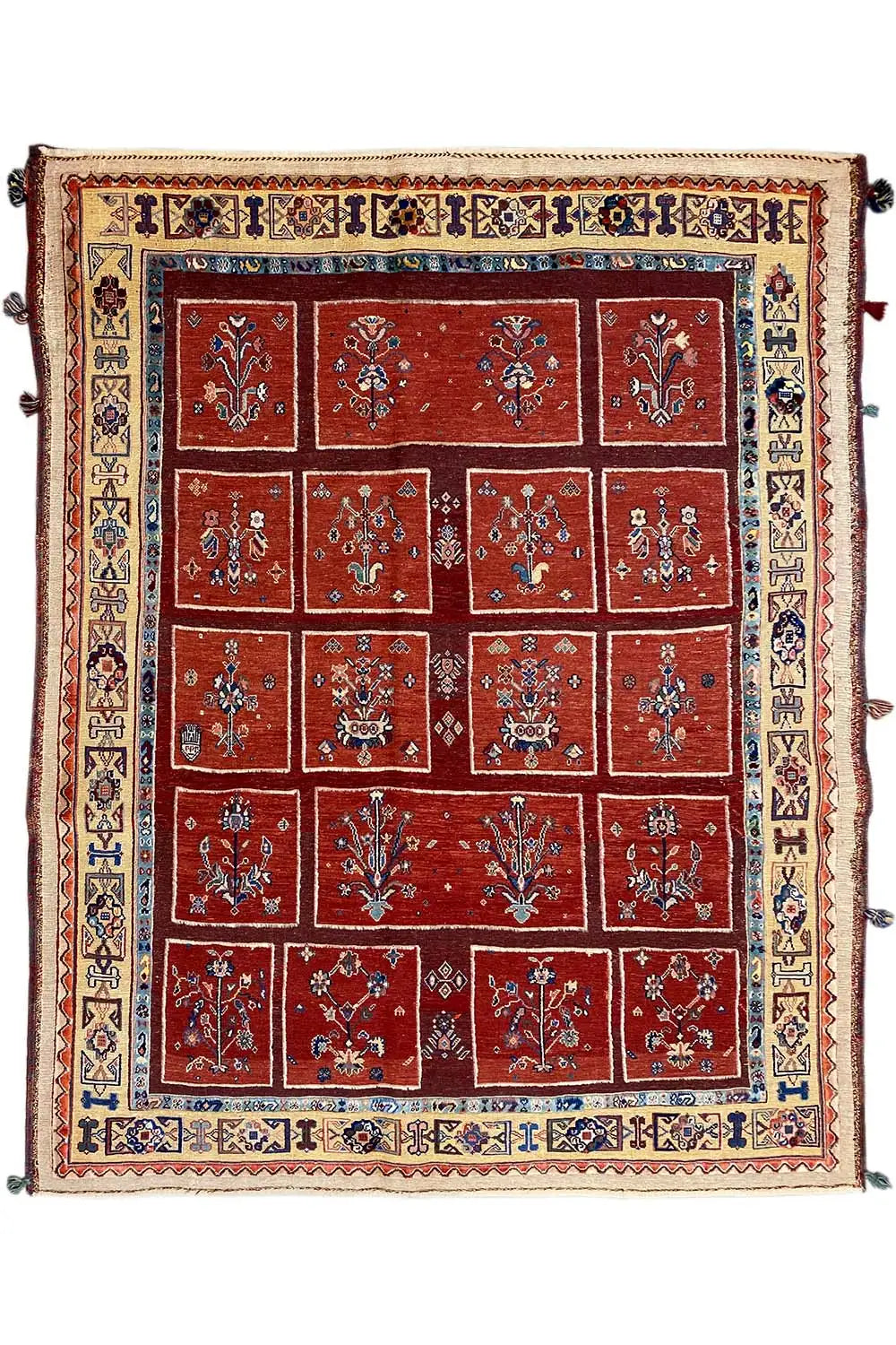 Square rug with a red tile pattern, blue inner border, and ornamental trim.