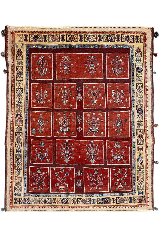 Square rug with a red tile pattern, blue inner border, and ornamental trim.